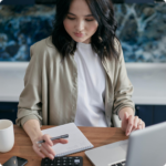 Virtual assistant working at desk with laptop, notebook, and calculator