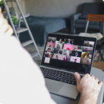 A person participates in a video call using a laptop in a cozy room